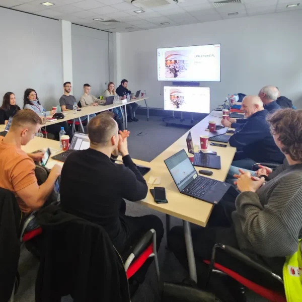 Szkolenie PRSES dla Coca Cola HBC: Uczestnicy z laptopami w sali konferencyjnej, z prezentacją na ekranach "PALETOWE.PL".